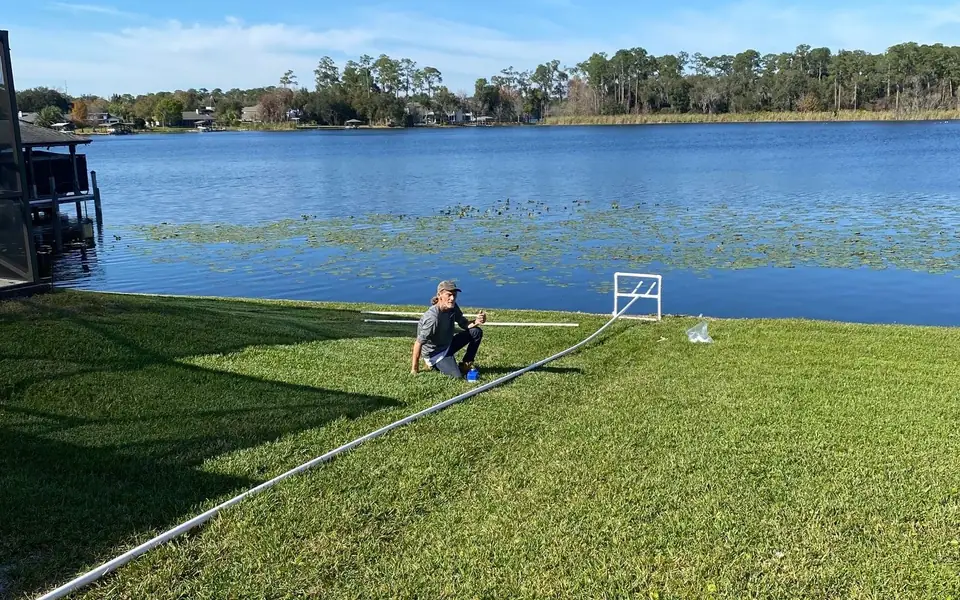 Lakefront lawn on an Orlando-area lake with an irrigation pump line running to the water