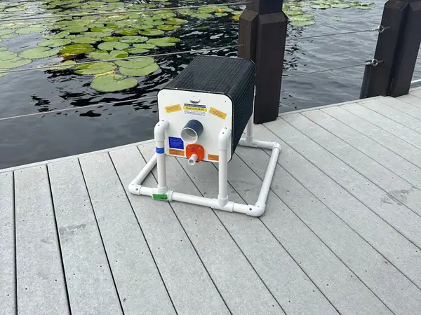 Lake-water irrigation pump on a dock above lily pads