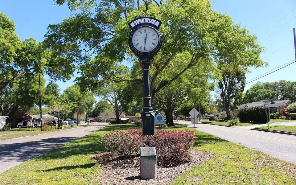 The Belle Isle street clock in a mulch bed on an oak-shaded residential street
